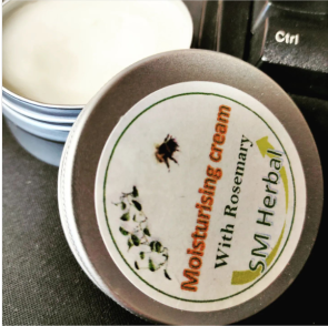 A photograph of a tin containing rosemary infused skin cream